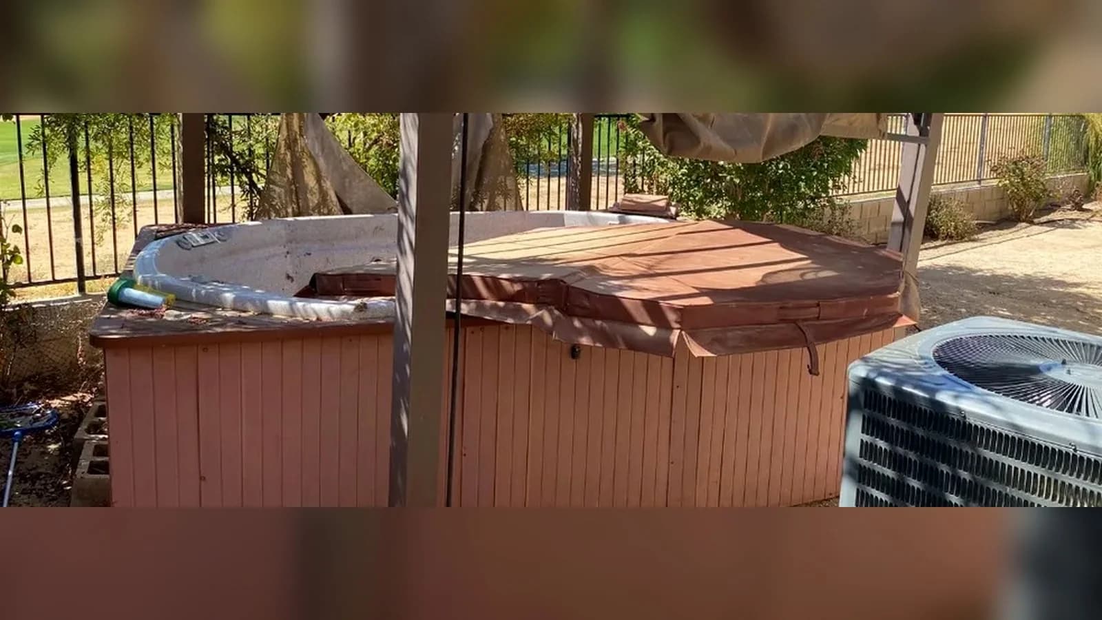 Backyard hot tub and surrounding patio before removal.