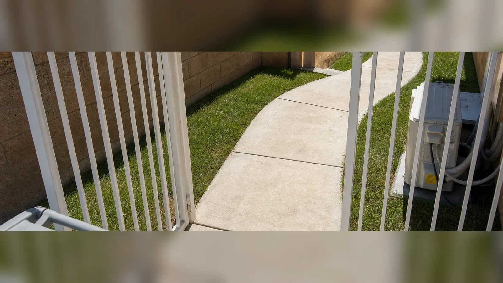 Clean side-gate walkway after bags, cardboard, containers, and household junk were removed.