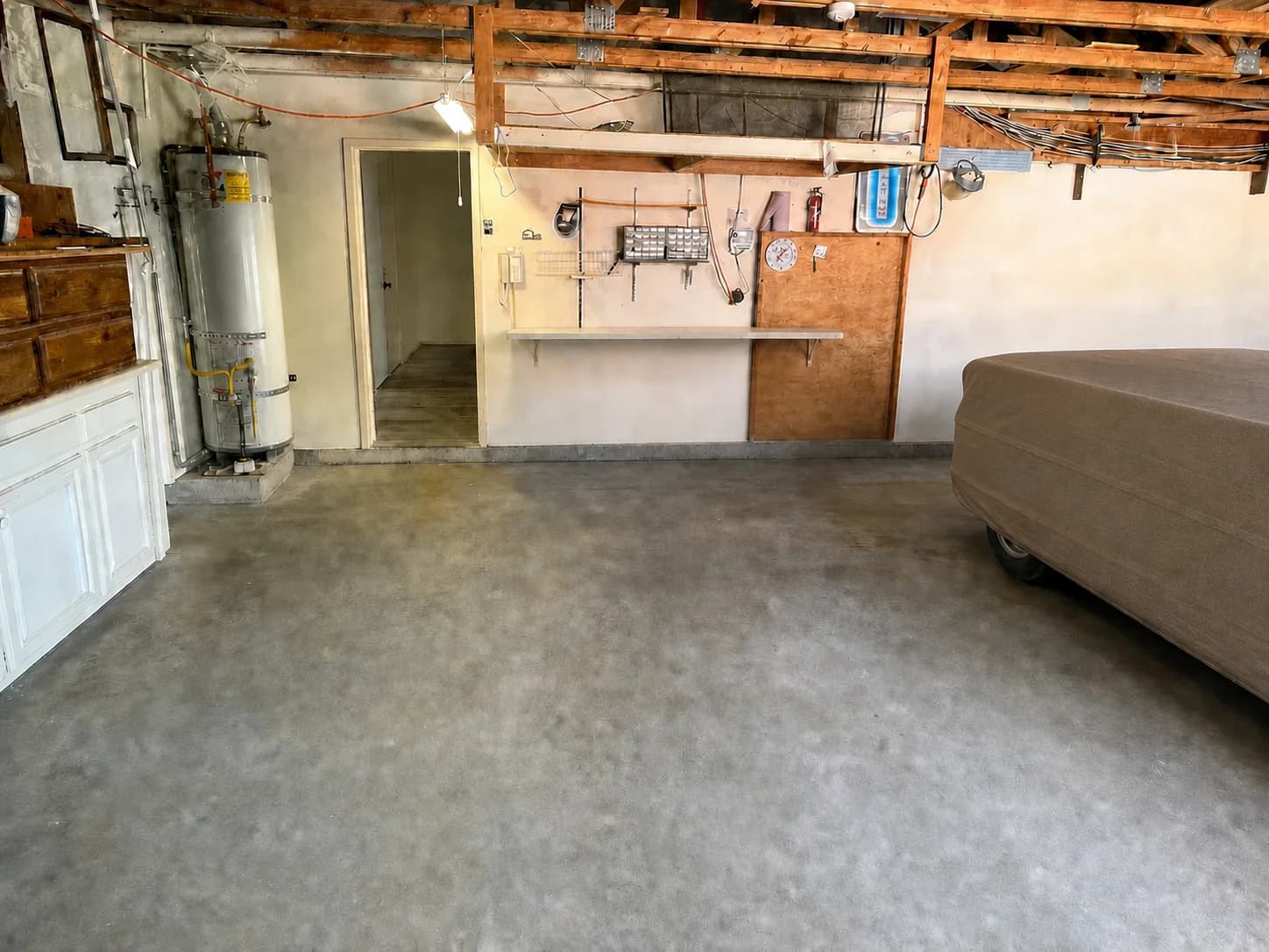 Cleanup visualization of the same garage with the removable clutter cleared and the concrete floor swept.